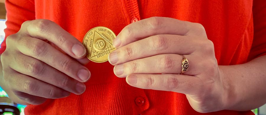 woman holds her AA chip