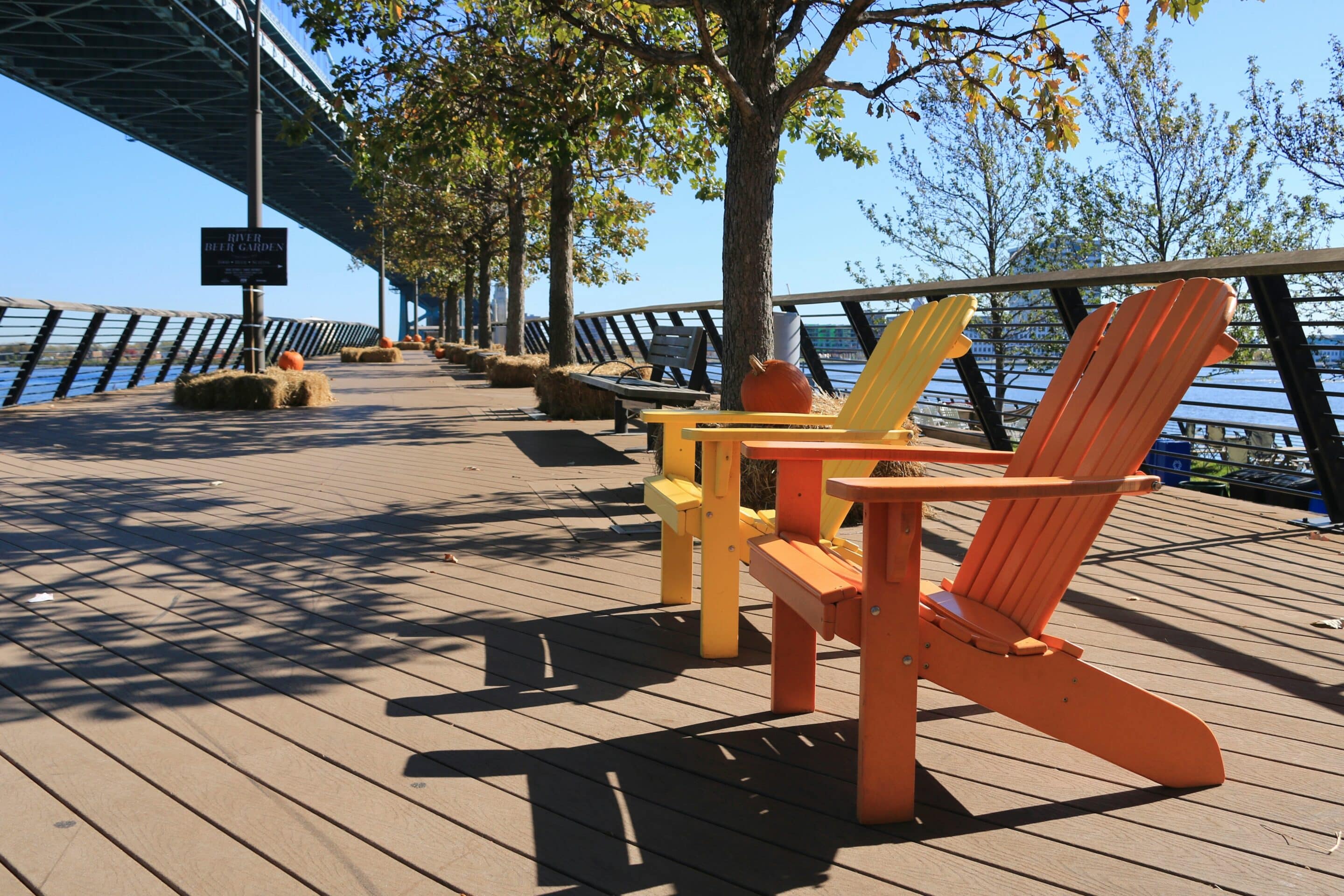 Bright Adirondack chairs along the Philadelphia riverfront near the Ben Franklin Bridge.