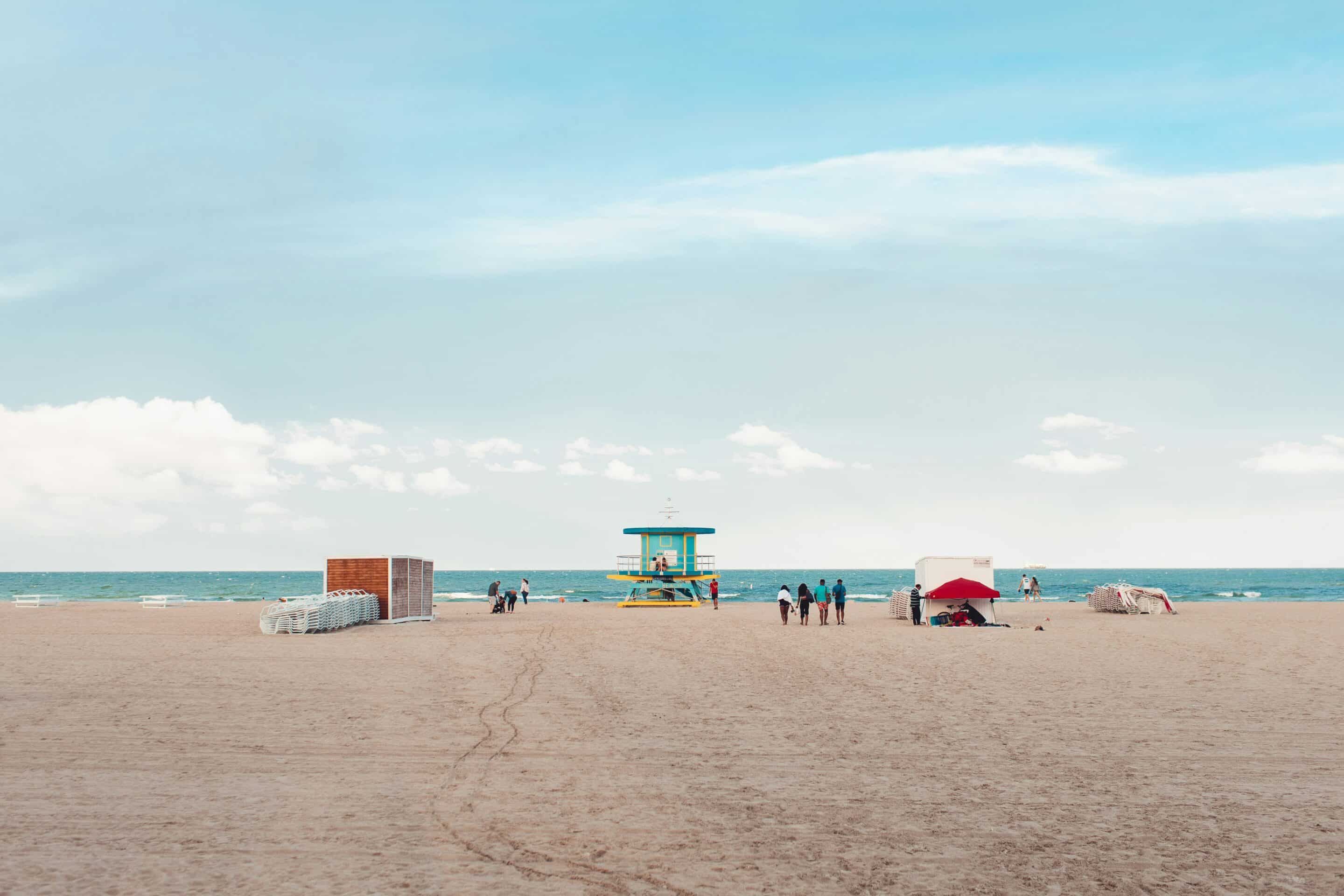 Miami Beach lifeguard stand and people enjoying the ocean near recovery housing.