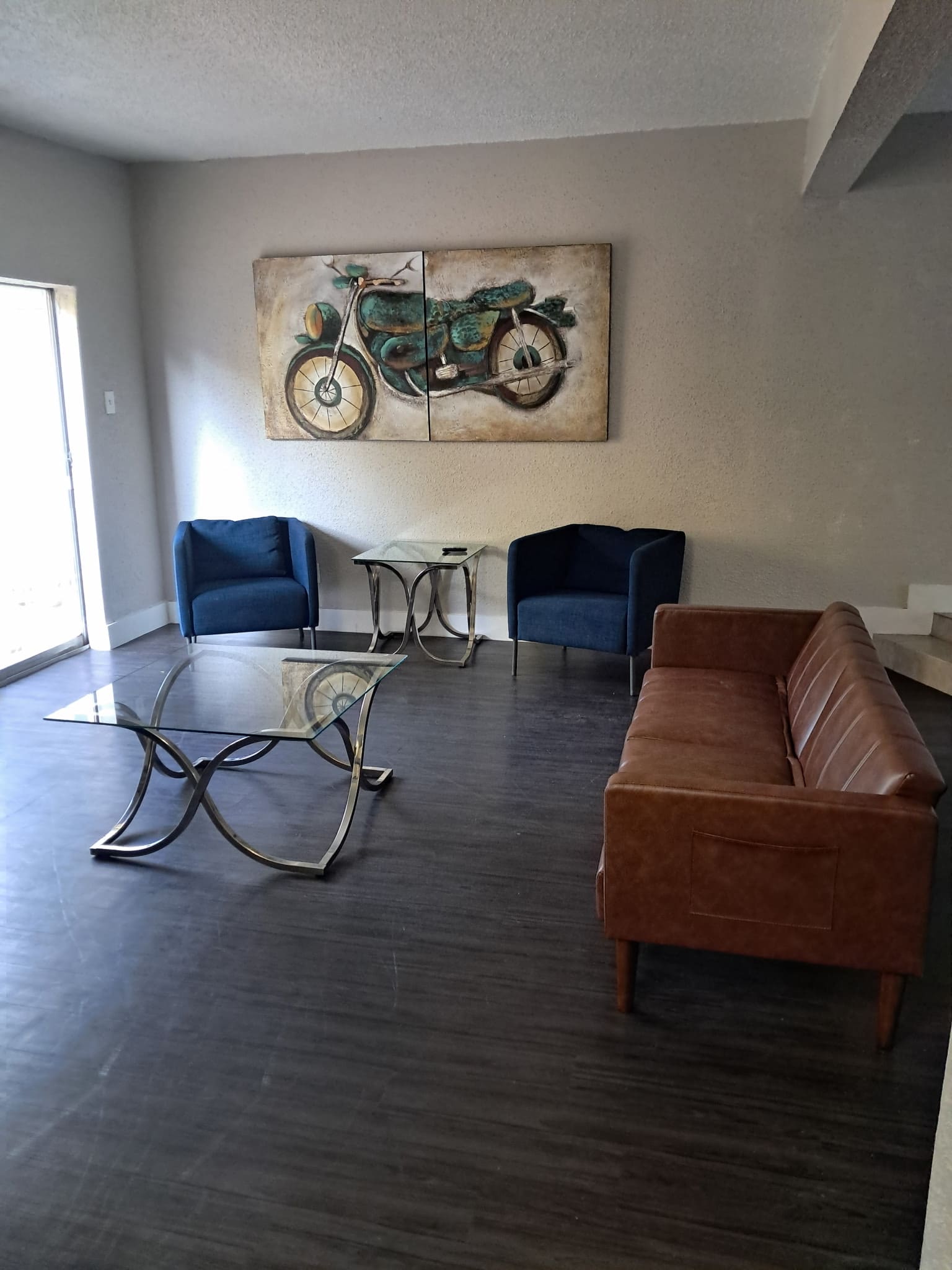 Two-man suite sober living in Austin with modern furniture, glass coffee table, and leather sofa