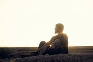 a man sitting on top of a rock near the ocean -- Photo by Kaushal Amrutiya on Unsplash