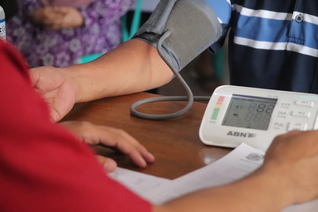 a person with a blood pressure meter on a table -- Photo by Mufid Majnun on Unsplash