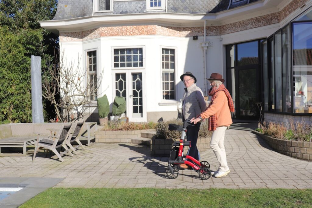 Two people with a walker by a modern house -- Photo by Mobio Marketing on Unsplash