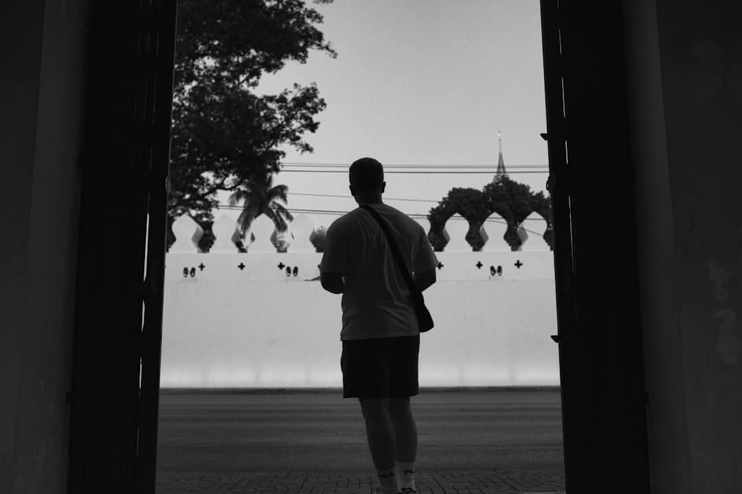 a man standing in an open doorway looking at the sky -- Photo by ASTRONAUD23 ㅤ on Unsplash