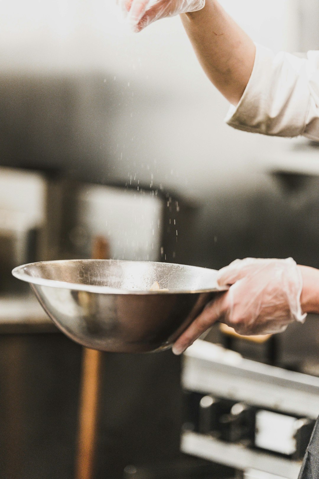person garnishing on gray stainless steel bowl -- Photo by Bank Phrom on Unsplash