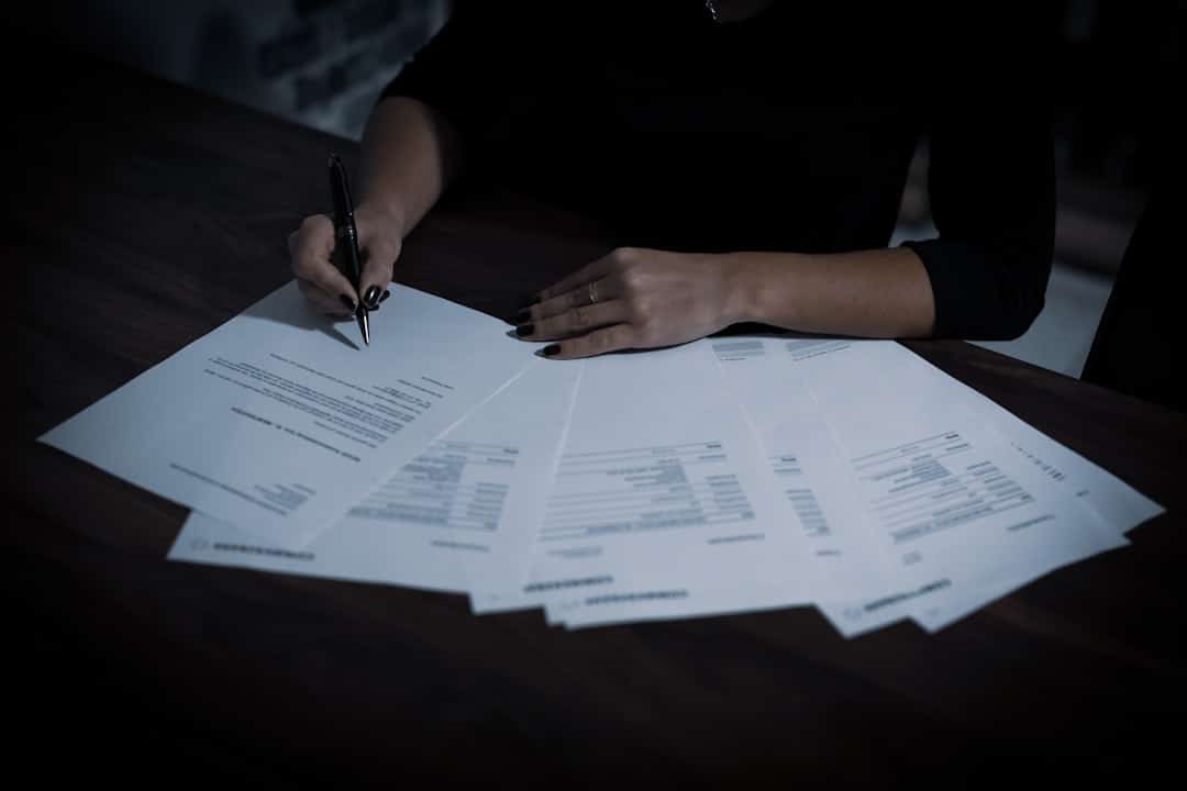 a woman sitting at a table with lots of papers -- Photo by Dimitri Karastelev on Unsplash