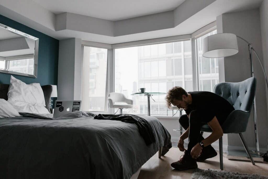 woman in black t-shirt and black pants sitting on bed -- Photo by Andrew Neel on Unsplash