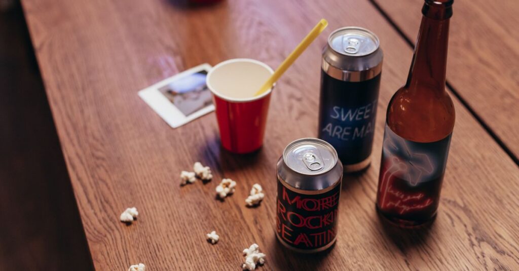 Close-up of assorted drinks and snacks on a wooden table, evoking a casual gathering vibe.