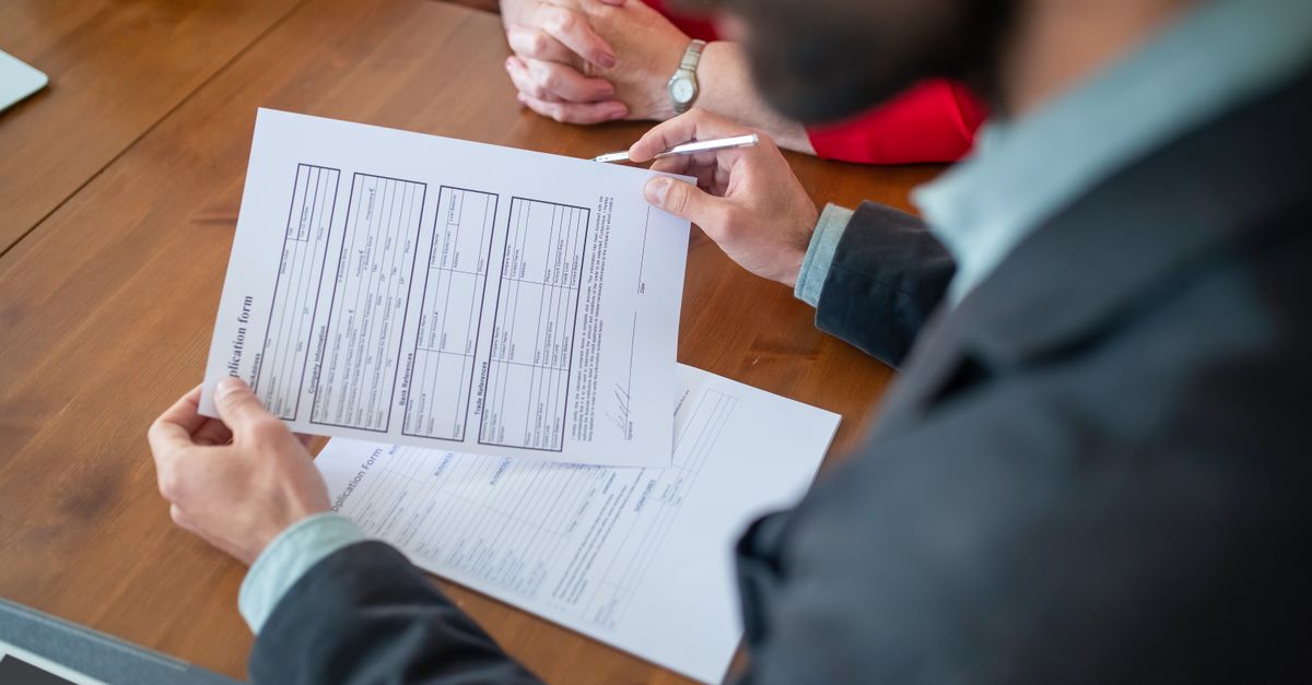 Close-up of businesspeople reviewing documents at a meeting.
