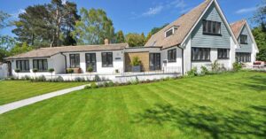 Contemporary house exterior with large manicured lawn and beautiful garden.