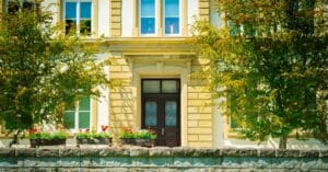 Sophisticated architecture with flowers and trees enhancing a stately European facade.