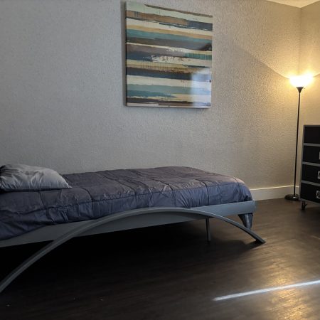 Shared two-bedroom men’s sober living space in Austin with twin beds and modern décor