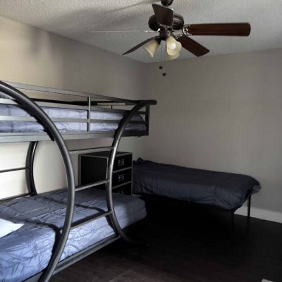 Shared living area in men’s sober housing Austin with brown sofa and glass tables