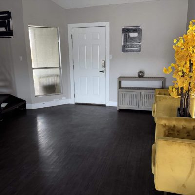 Austin men’s sober apartment living room with TV, couch, and dining area