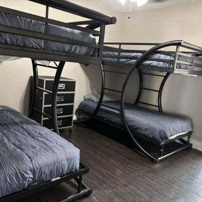 Shared men’s sober living room with bunk beds and window lighting in Austin TX