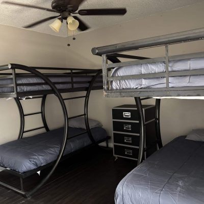 Affordable men’s sober living bedroom in Austin with twin bunks and modern dark flooring